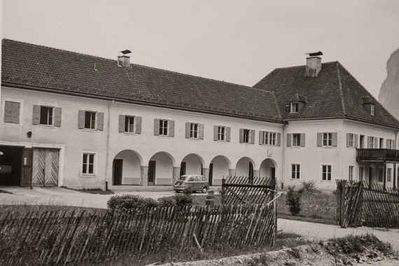 The picture shows a black and white photo of the main building in Scharfling am Mondsee (taken diagonally from the side).