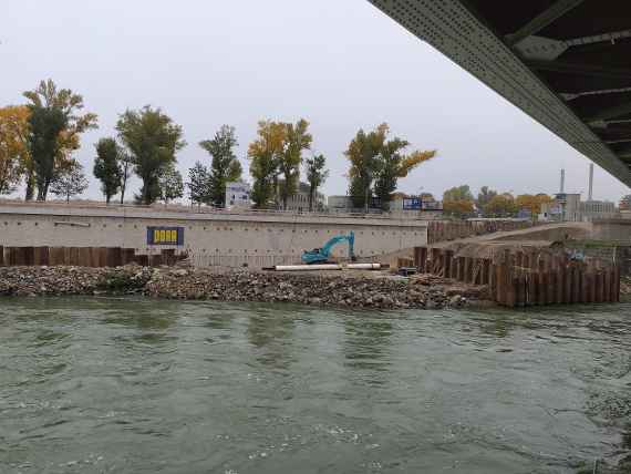 The Danube runs transversely, on the opposite side you can see the wall that has long since been raised, and above it is a railroad bridge.