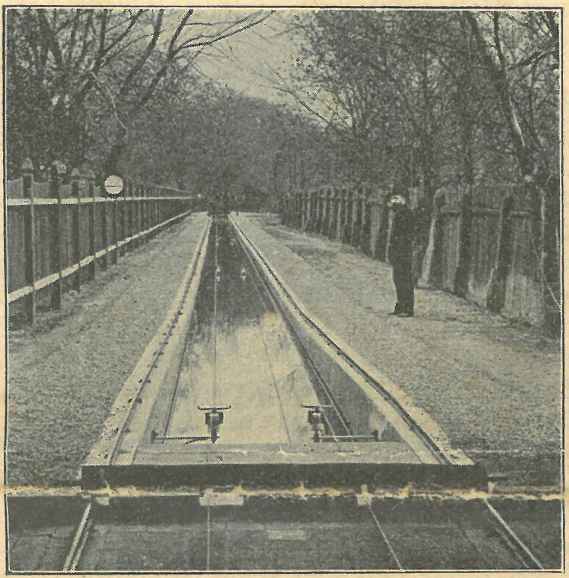 The picture taken at that time shows (according to the publication of the article at that time) a view from the station house, to the measuring canal. The facility was fenced all around with fences about 1.7 m high. Behind the fences to the left and right of the canal, you can see very tall trees. The tracks along the canal have a gradient at the beginning to reach the maximum speed very quickly. Above the water, two wires run parallel. A worker is standing to the right of the measuring channel.