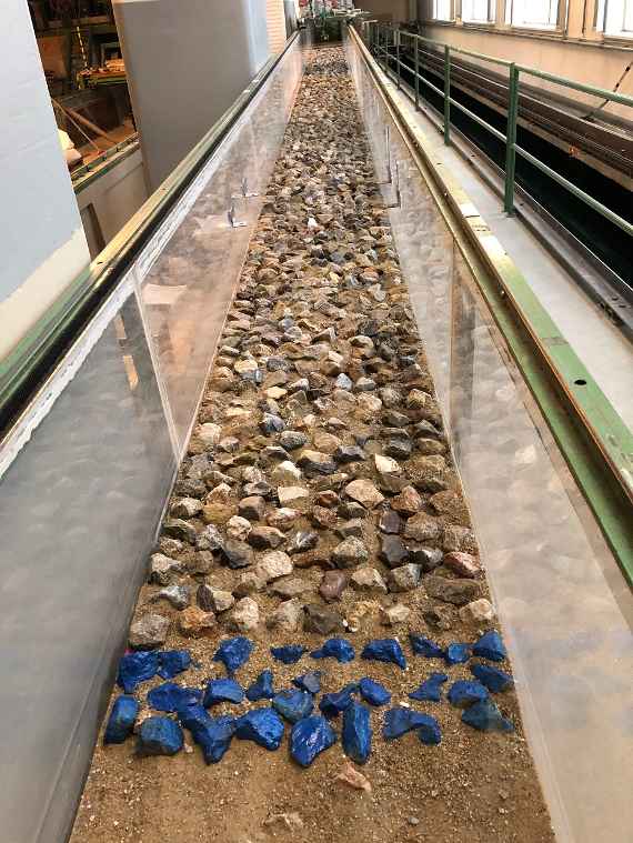 You can see the same flume as in the previous picture. The view now goes against the direction of flow. The lower end of the model is also marked with three rows of blue coloured stones.