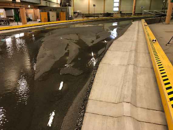 You can see a river branching into several partial streams in a hydraulic engineering model test in a hall.