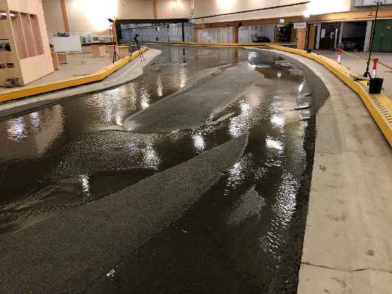 A river branching into two partial streams in the hydraulic engineering model test in a hall is to see.