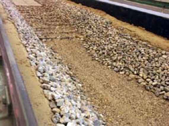 A scour (depression in the riverbed) has formed downstream of the structured ramp after an centennial flood flood in the model experiment