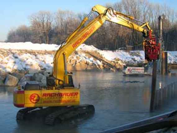 Removal of the steel sheet piling required to secure the construction site with an excavator.