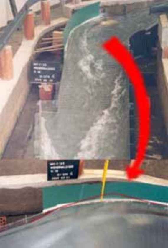 Flood discharge in the weir channel with raised baffle wall on the outer curve, you can see the flood spillway in the design discharge with raised wall on the outer bank in the curve. A red arrow refers to a second picture below with a detailed view of the baffle wall.