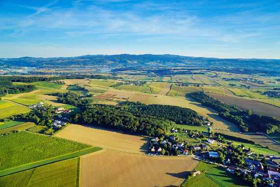 The aerial photo shows the site of the Hydrological Open Air Laboratory, with variously coloured fields, meadows and a wooded area in somewhat cloudy weather.