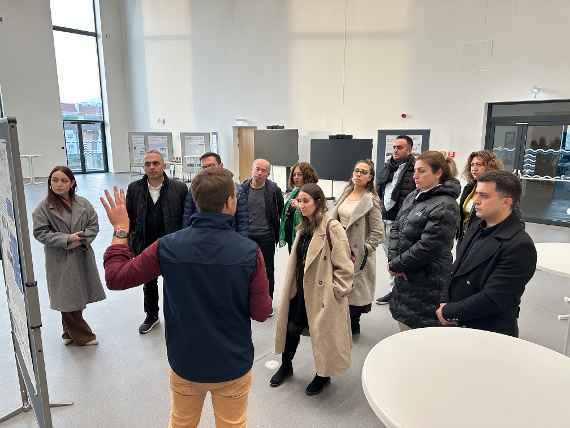 Die Mitarbeiter:innen der türkischen Ministerien stehen in der Veranstaltungshalle im Wasserbaulabor und hören gespannt unserem BAW-Mitarbeiter Martin Hasenhündl, der durch das Haus führt zu.