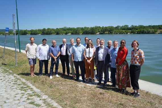 Gruppenfoto mit 14 Personen, im Hintergrund ist die Donau zu sehen.