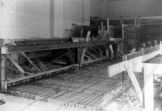 Ein Arbeiter montiert Eisenstangen als Bewehrung für die Bodenplatte der Wasserbauversuchshalle.