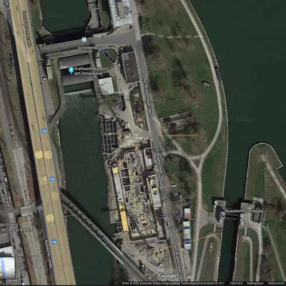 Das von einem Satelliten aufgenommene Bild zeigt das Grundstück während der Bauarbeiten Ende 2020. Links vom Grundstück sieht man den Donaukanal mit dem Wasserkraftwerk Nußdorf, rechts die Donau.