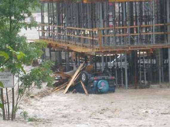 Eine Baustelle, welche durch Hochwasser angespült wurde inklusive eines Autos, das Gebäude ist eingerüstet.