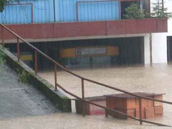 Ein durchströmtes Gebäude, links ein Steg hinauf zum Gebäude mit Geländer, rechts alles unter Wasser.