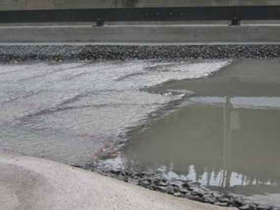 Bild des Modellversuchs mit dem oberen Teil der Rampe. Das Wasser strömt langsam auf die Rampe zu und wird schneller. Der dargestellte Abfluss entspricht circa 500 Kubikmeter pro Sekunde in der Natur. Dies entspricht etwa dem doppelten mittleren Abfluss der Salzach in diesem Bereich.