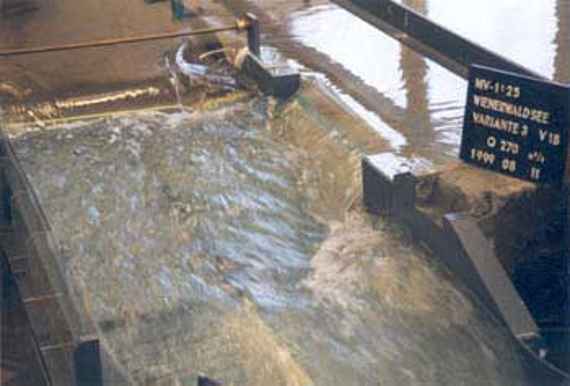 Ansicht der beiden Überfallwehre (Stauklappe und feste Wehrschwelle), man sieht die beiden Überfallwehre im Detail beim Bemessungsabfluss von hundertjährlichem Hochwasser und den Beginn der Schussrinne.
