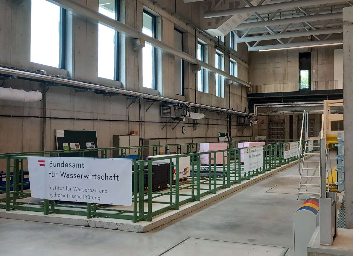 The river construction channel of the Institute for Hydraulic Engineering and Hydrometry under construction: steel elements, which form the static frame of the channel, stand on a concrete foundation. Further construction material stands inside the steel boundary.