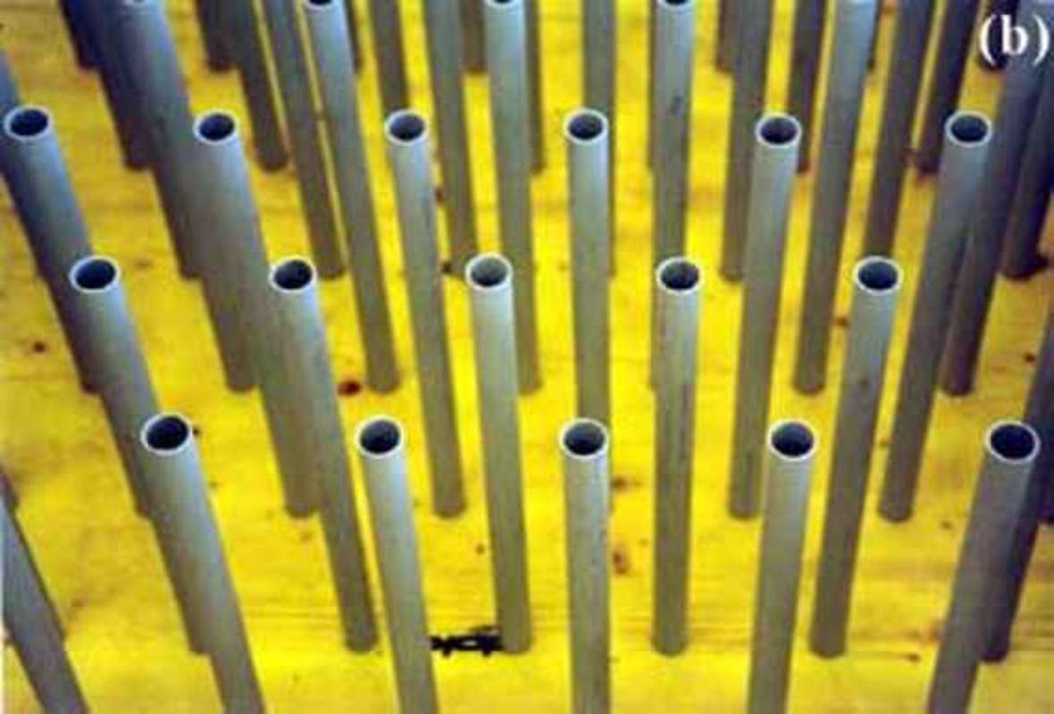 Grey pipes with a diameter of thirty-two millimeters, which simulate plant growth, are fixed in a yellow formwork panel on the floor.
