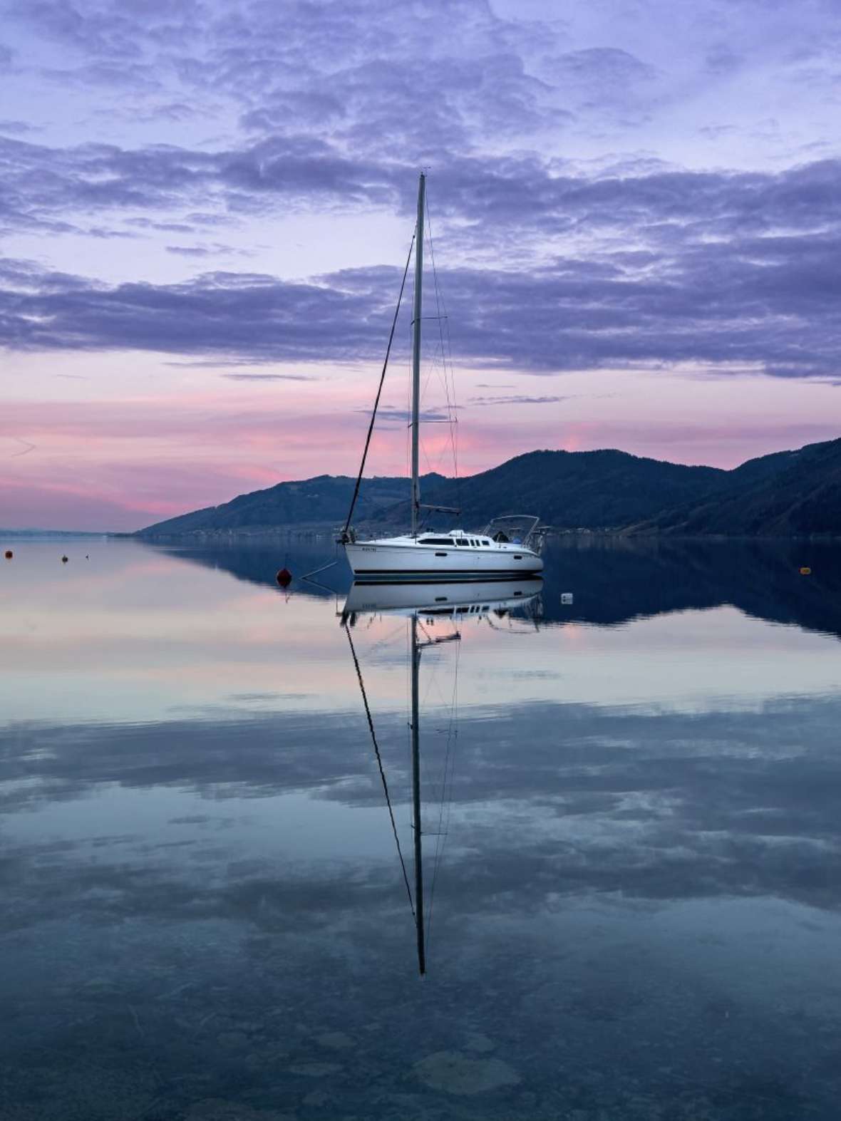 Jury Platz 5: Ein Segelschiff ruht ruhig im See. Der Himmel gefärbt in Rosa.