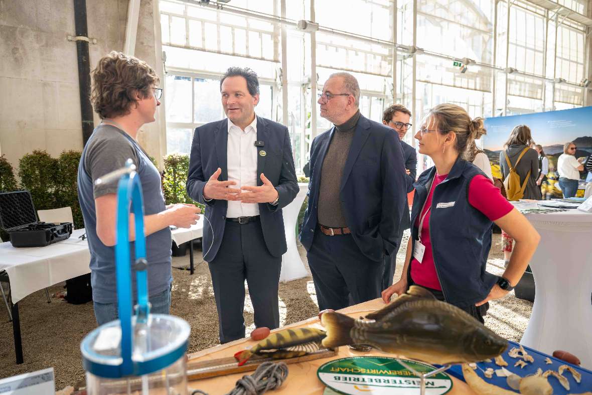 BAW-Mitarbeiter Florian Keil, BAW-Direktor Peter Strauss, BM Norbert Totschnig und Institutsleiterin Daniela Achleitner stehen vor dem Infostand des IGF im Palmenhaus. 