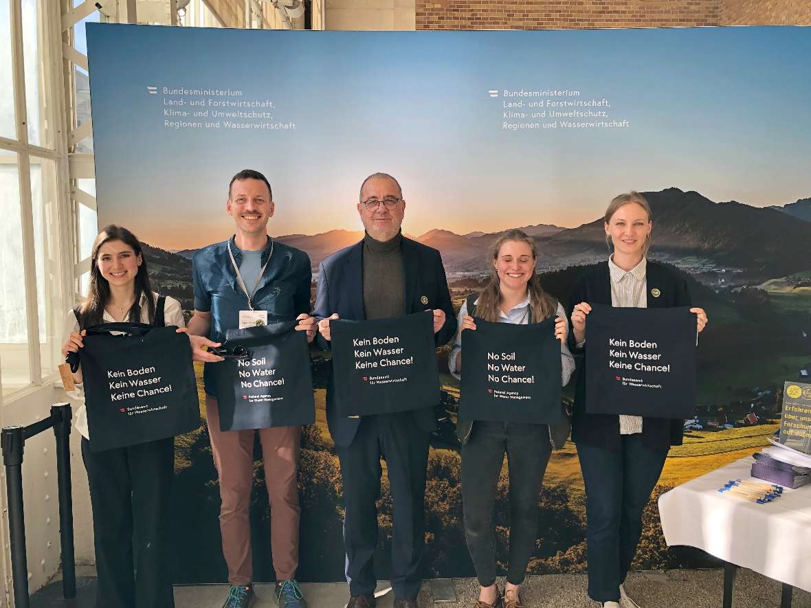 BAW-Direktor Peter Strauss und Mitarbeiter:innen des BMLUK mit unser BAW-Stoffbeutel in der Hand.