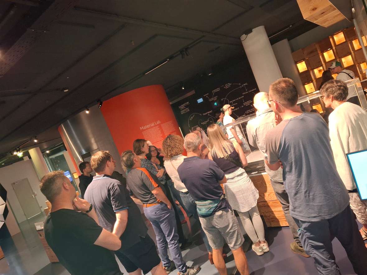 Ars Electronica: Führung durch das Museum – Auf dem Foto ist eine Gruppe von BAW-Mitarbeiter:innen während der Museumsführung von hinten zu sehen.