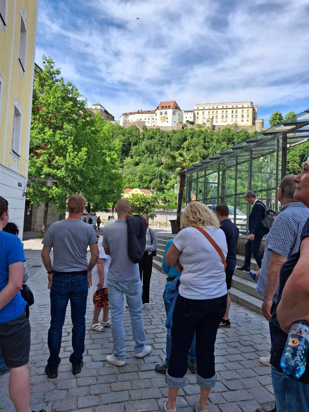 Passau: Auf dem Foto ist eine Gruppe von BAW-Mitarbeiter:innen während der Führung durch Passau zu sehen. Im Hintergrund die Burganlage Veste Oberhaus.
