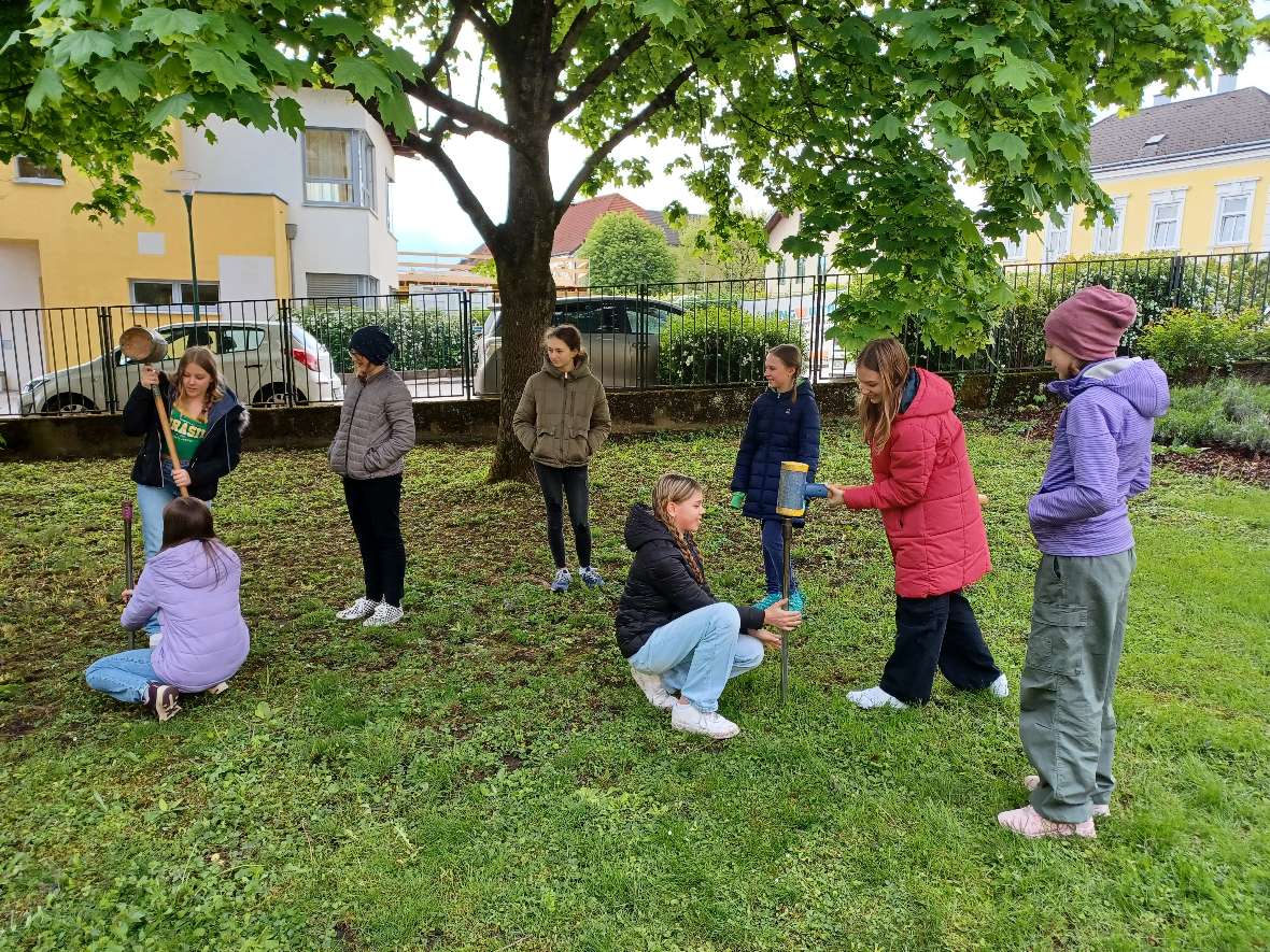 Den Mädchen wird im Garten des Institutes die Entnahme von Bodenproben gezeigt. 