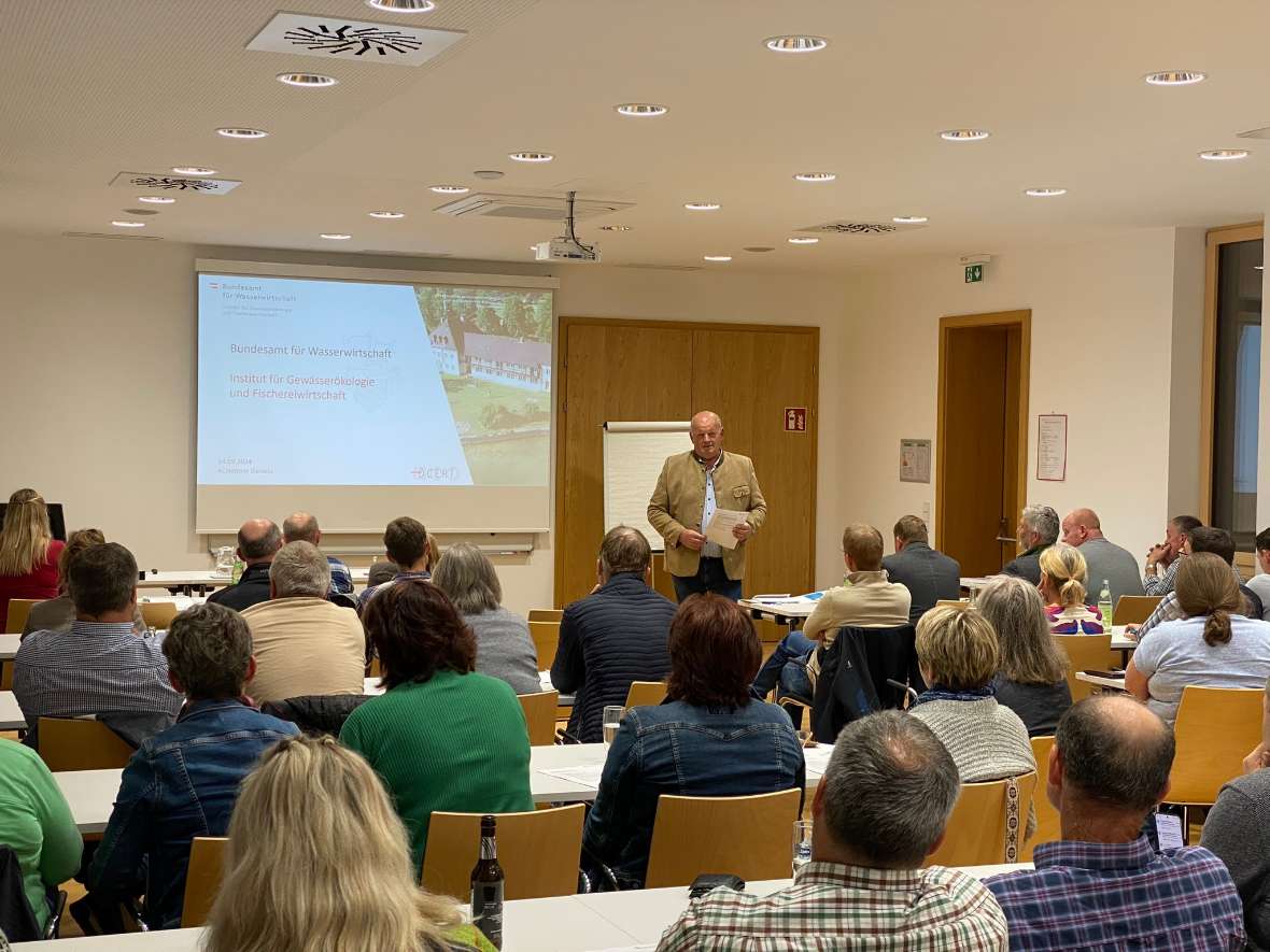 Bezirksbauernkammerobmann Alfred Lang begrüßt im Sitzungssaal der Bundesamtes für Wasserwirtschaft die Bezirksbauernobleute und Bezirksbäurinnen Vöcklabruck. Auf der Wand sieht man eine Präsentation mit dem Titel Bundesamt für Wasserwirtschaft.