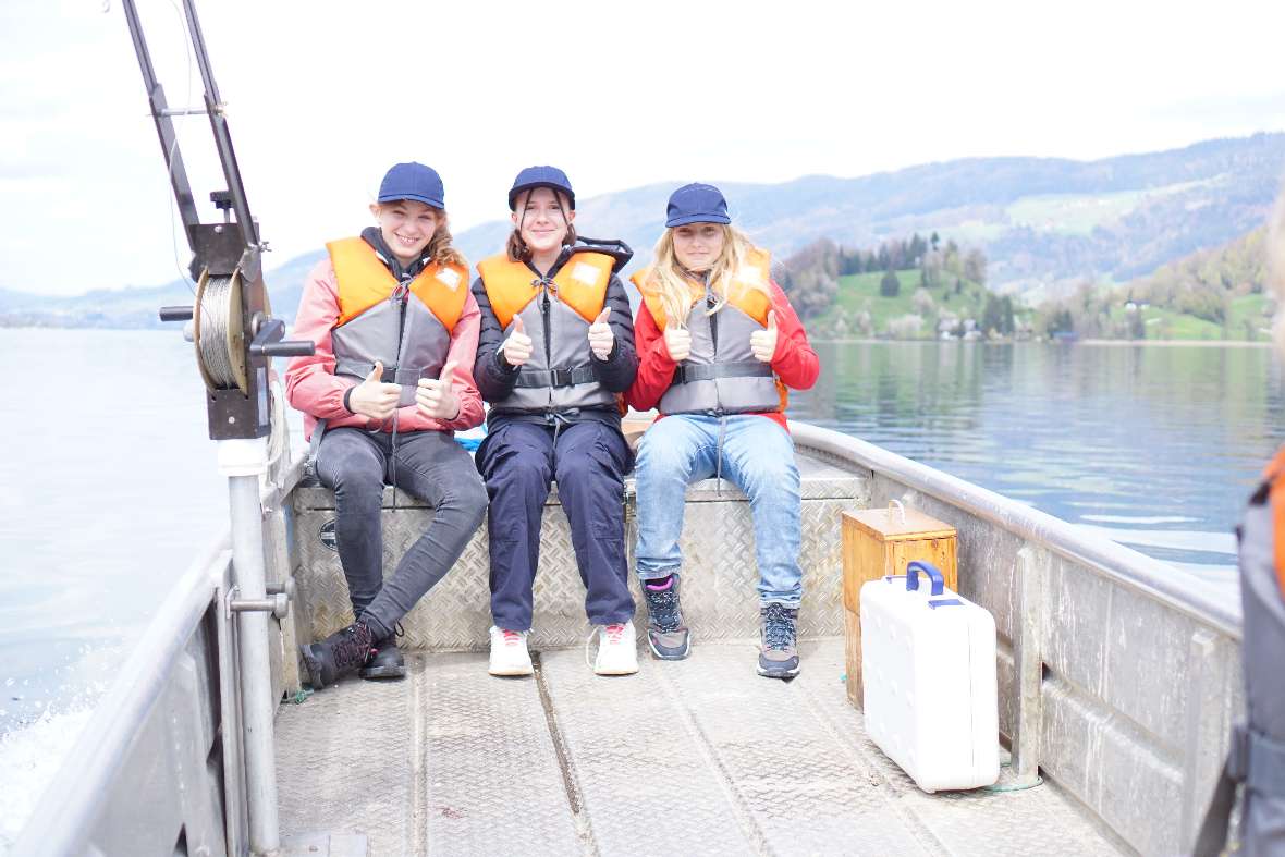 3 Schülerinnen am Boot mit Daumen nach oben 
