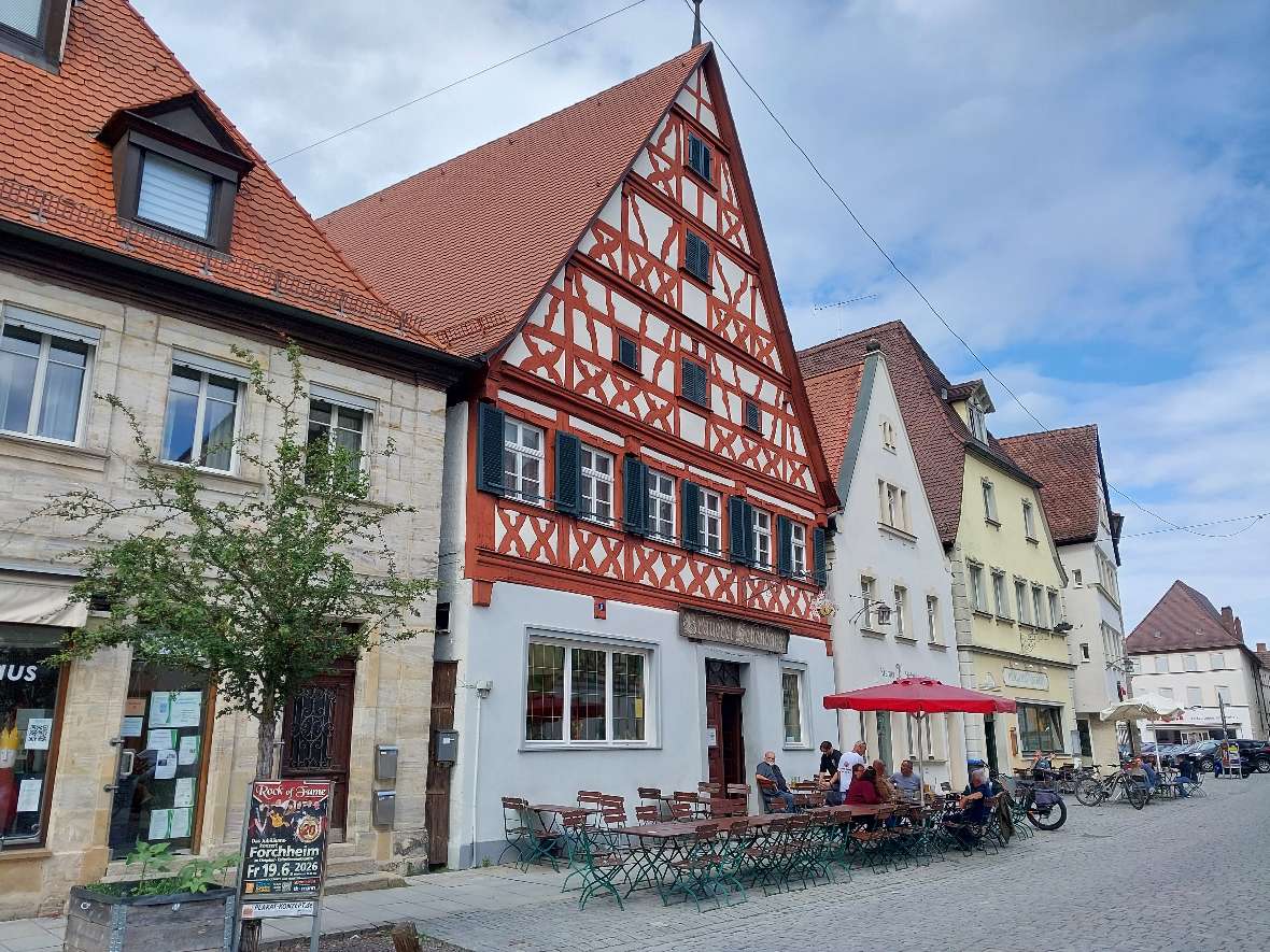 Das Bild zeigt eine gepflasterte Straße in Forchheim mit zum Teil sehr alten Häusern, teilweise in komplexer Fachwerksbauweise. Fachwerksbauten sind in Forchheim noch relativ oft zu sehen in der Innenstadt, manche davon sind mehrere Jahrhunderte alt.