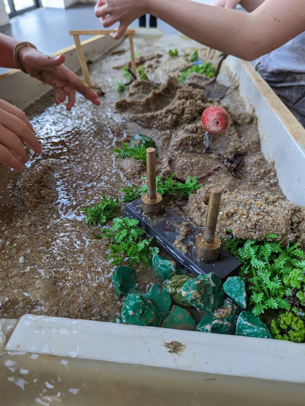 Die Morphologierinnen des Institutes für Wasserbau: in kleinen Gruppen von zwei bis drei Schüler:innen konnte der Gerinneverlauf unterschiedlichst gestaltet und beeinflusst werden.