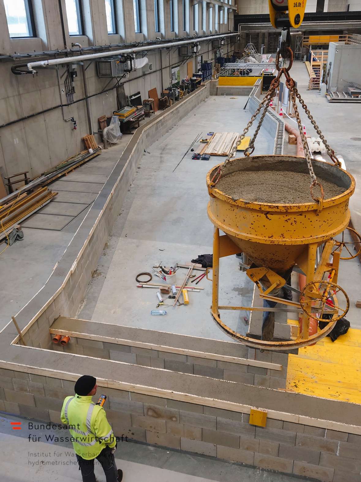 Aufbau einer 150m² großen Versuchsrinne - Befüllung der Schalungssteine mit Beton 