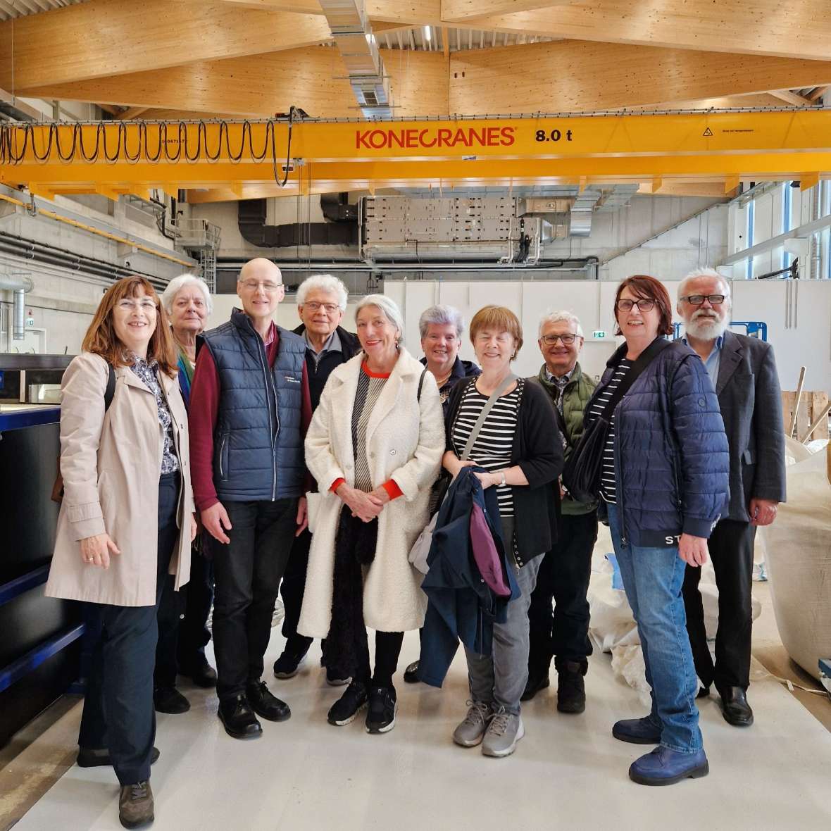 Ein Gruppenbild mit 9 Mitglieder:innen der Vereinigung Öffentlicher Mandatar:innen sowie dem Leiter des Instituts für Wasserbau und hydrometrische Prüfung, die sich in einer Halle des Wasserbaulabors befinden.