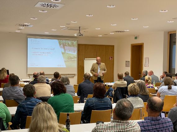 Bezirksbauernkammerobmann Alfred Lang begrüßt im Sitzungssaal der Bundesamtes für Wasserwirtschaft die Bezirksbauernobleute und Bezirksbäurinnen Vöcklabruck. Auf der Wand sieht man eine Präsentation mit dem Titel Bundesamt für Wasserwirtschaft.