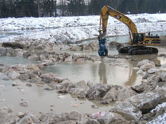Bild; Saalachrampe, auf dem ein Bagger steht, im Hintergrund Böschung mit Schnee zu erkennen